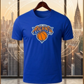 Blue t-shirt with sports team logo on a hanger, next to a basketball and sneakers, against a cityscape background.